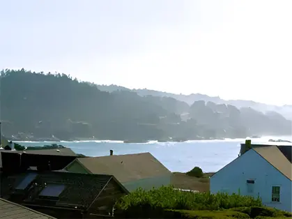 A view of the ocean from above houses.